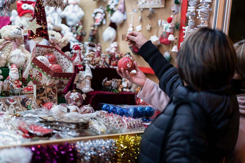 Una dona tria una bola de Nadal d’una de les parades de la Fira de Nadal a Sagrada Família