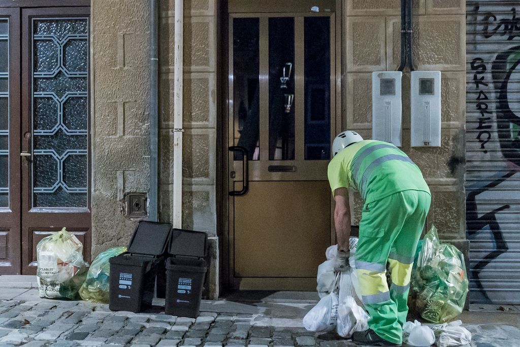 Recollida selectiva porta a porta al barri de Sarrià. Escombriaire recollint els sacs de la fracció orgànica del portals d'un edifici