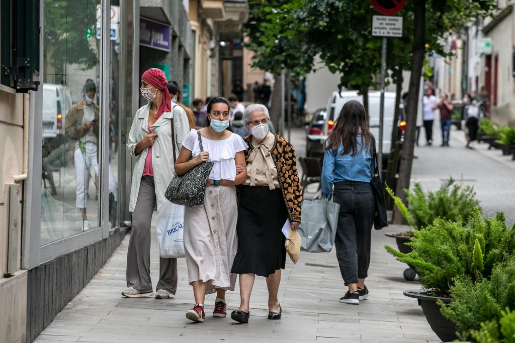 Unes dones passegen juntes pel carrer Major de Sarrià, ambdues amb mascaretes