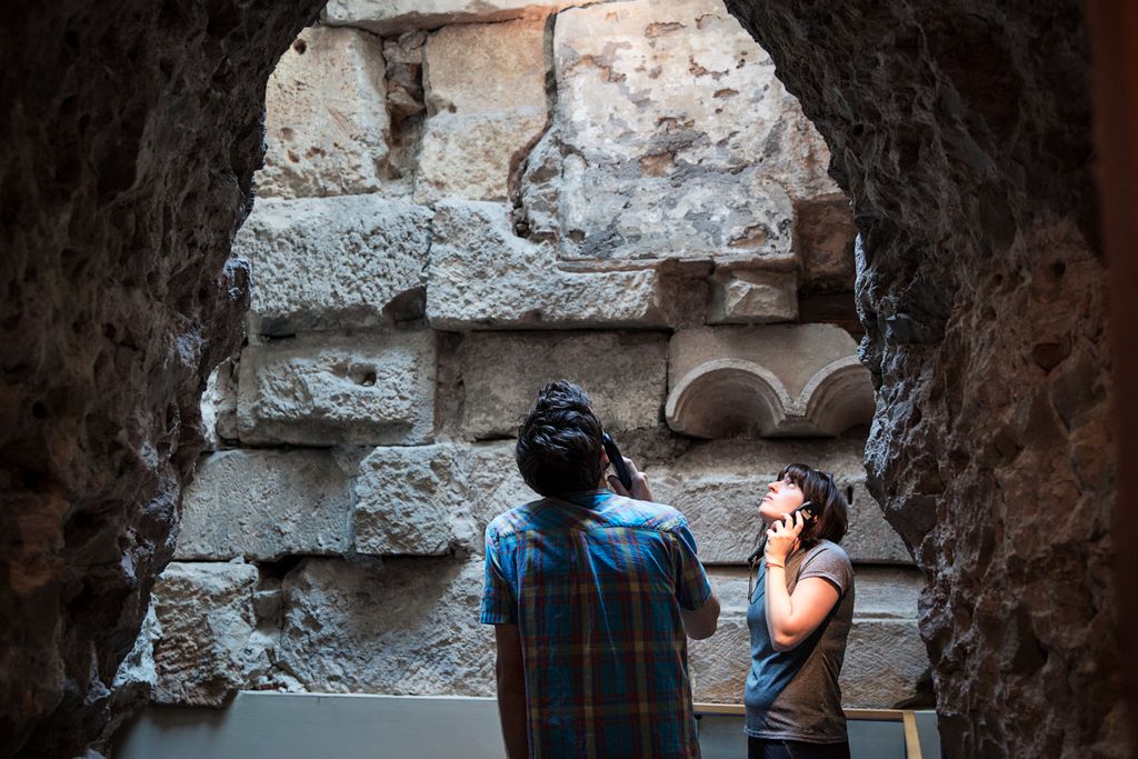 Museu d'Història de Barcelona. Visitants observant unes restes romanes i escoltant l'audioguia
