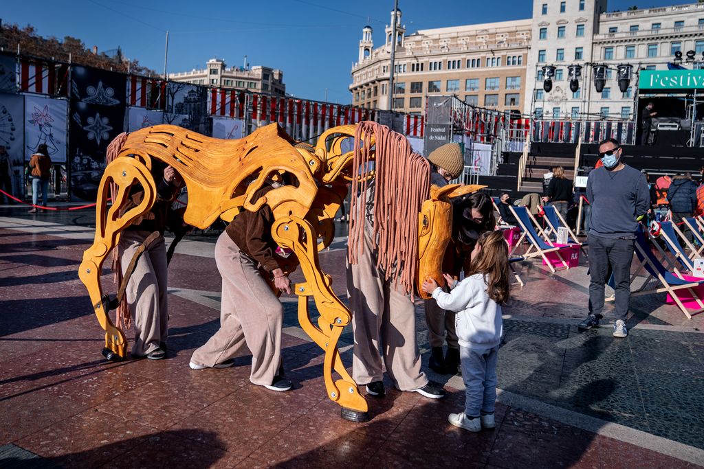 Una nena es mira una titella gegant d'un dels espectacles del Festival de Nadal de la plaça de Catalunya