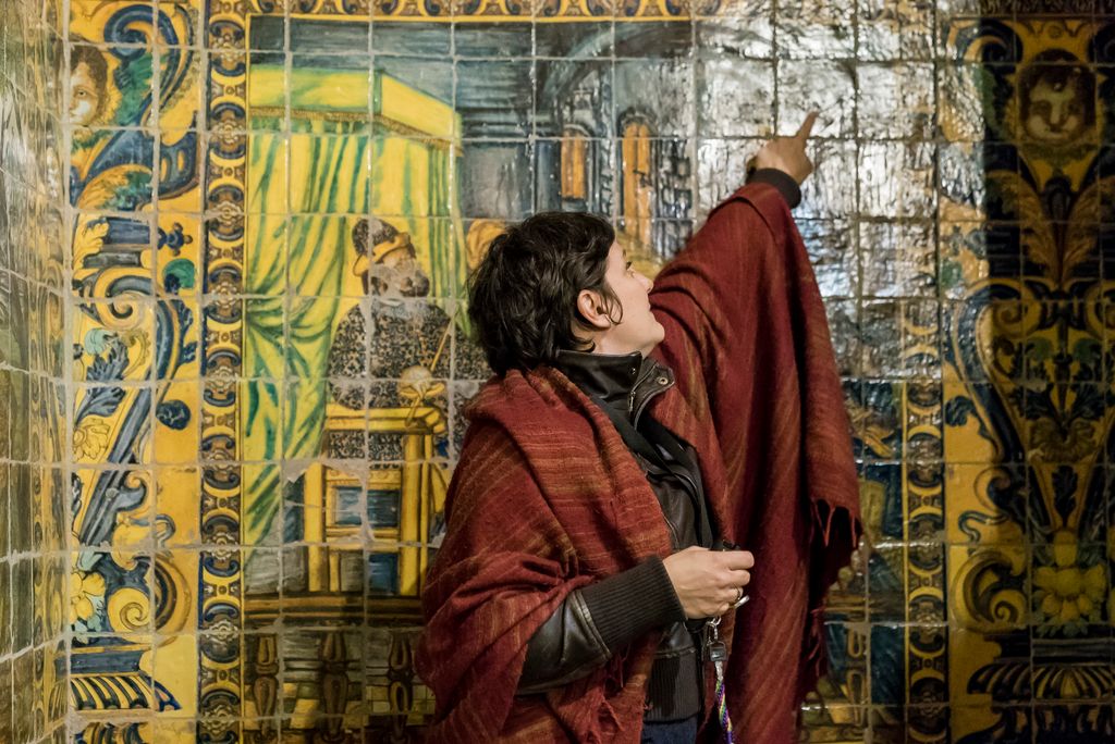 Guia mostrant els murals ceràmics que recobreixen les parets del vestíbul de l'Institut d'Estudis Catalans