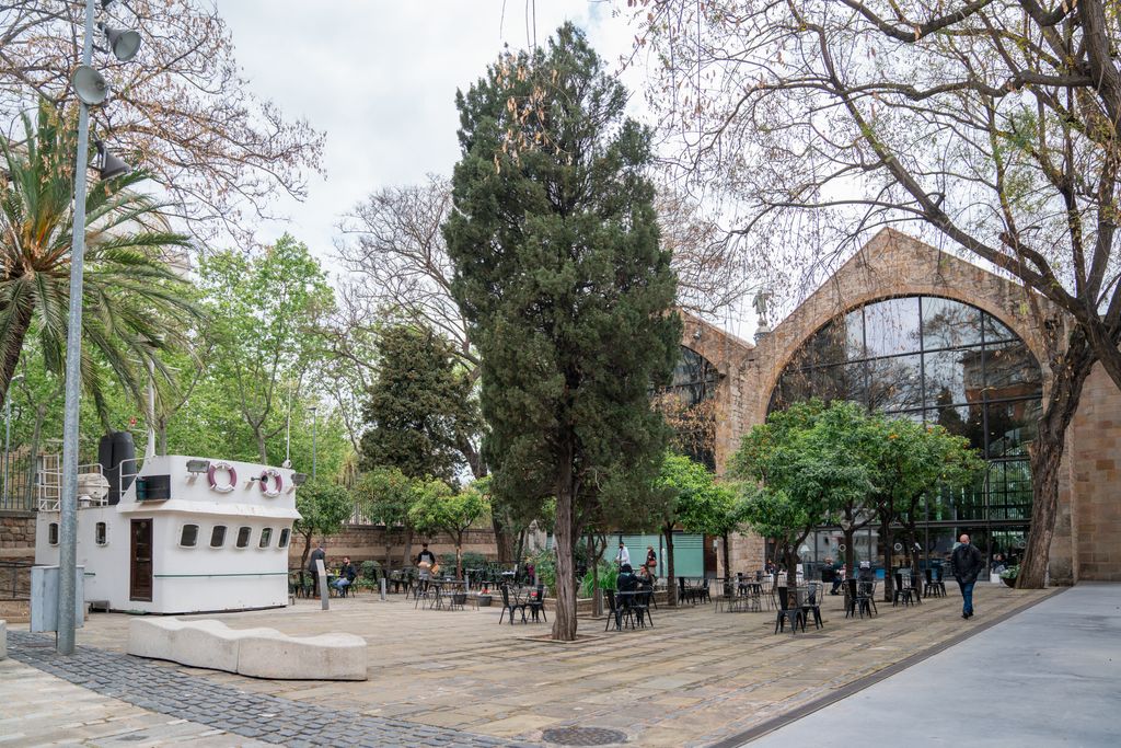 Voltants de les Drassanes Reials i porta d’entrada amb una terrassa exterior on hi ha la cabina d’un vaixell
