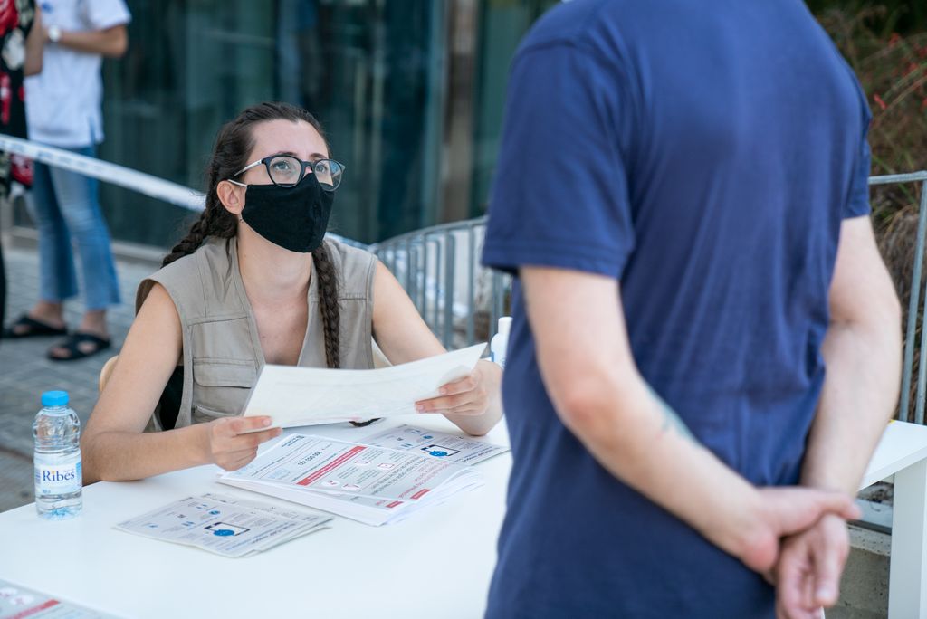 Una informadora explica el protocol que cal seguir a un ciutadà interessat a fer-se les proves PCR