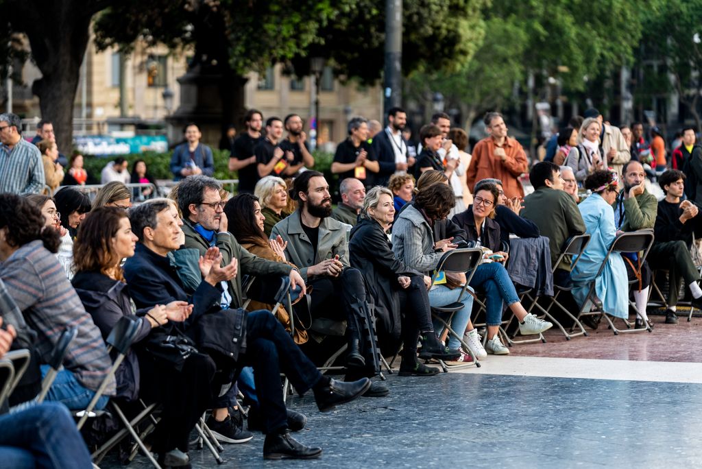 Asistentes a la inauguración del ModelFest se sientan en torno a una gran mesa circular en la plaza de Catalunya