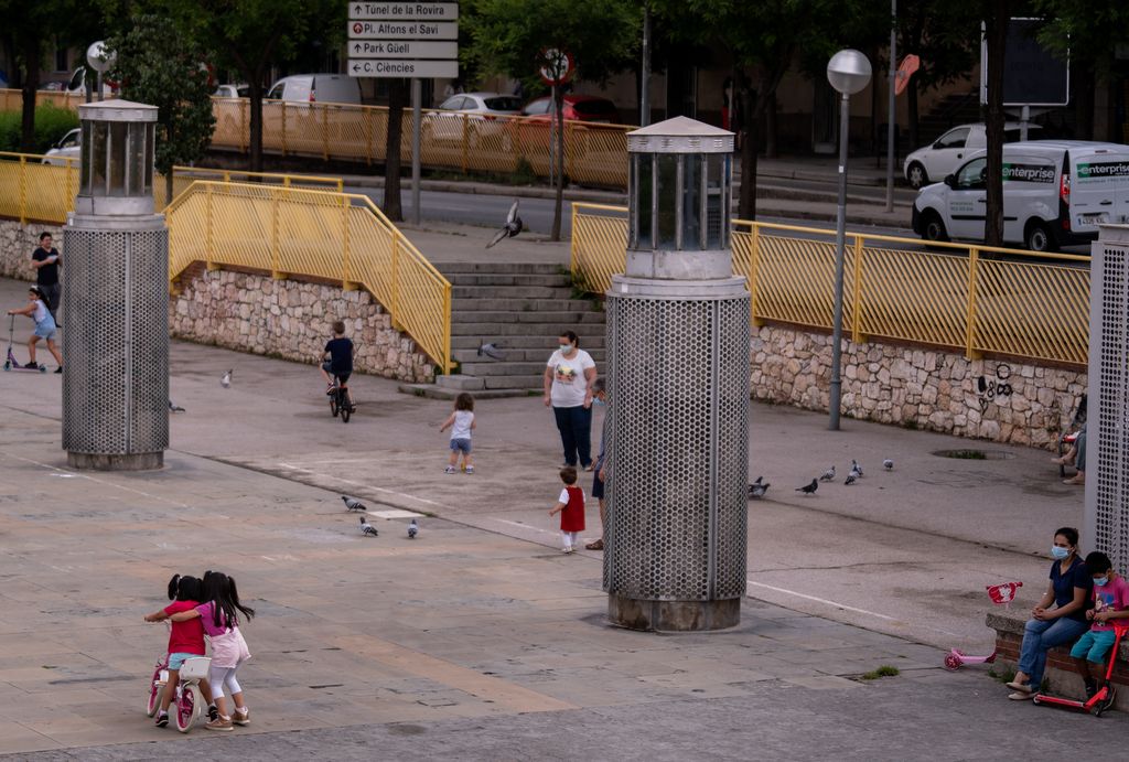 Petits grups de nens jugant a la rambla del Carmel sota la mirada de les seves famílies
