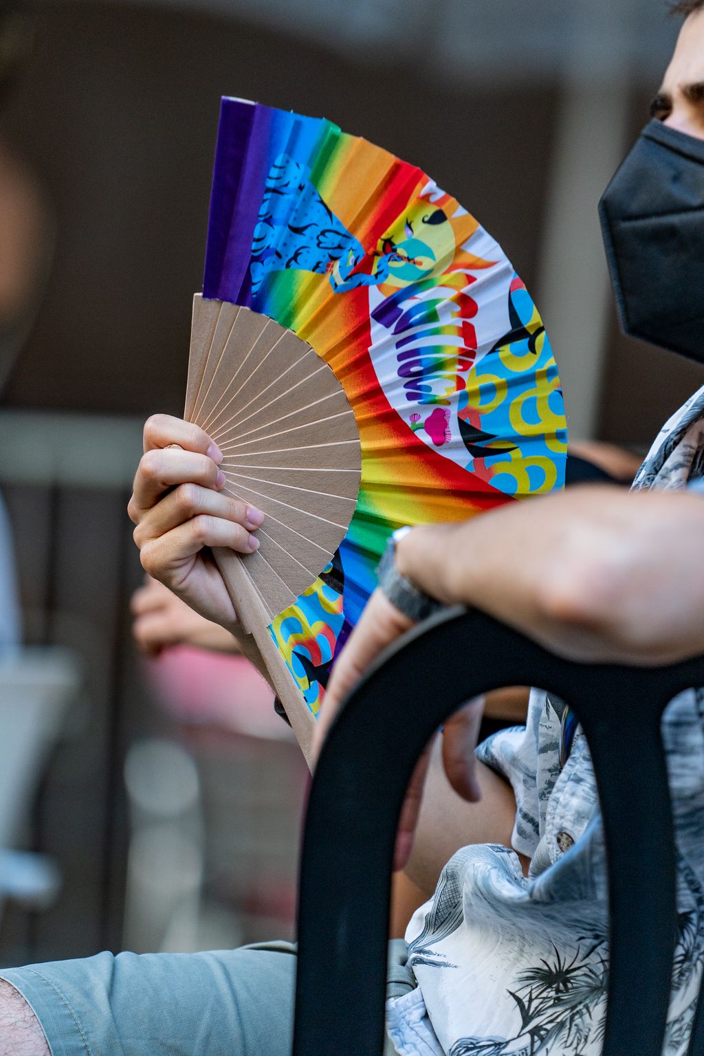 Una persona del públic es venta amb un dels ventalls de la campanya LGTBI durant la Festa d’Estiu del Centre LGTBI