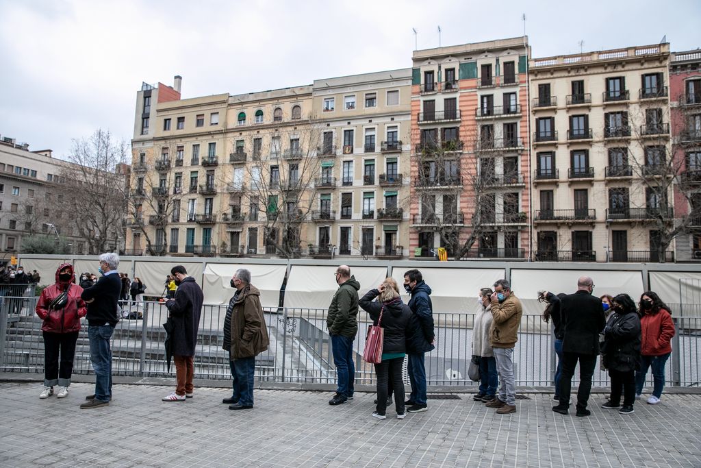 Votants que fan cua a l'exterior del Mercat de Sant Antoni, tot esperant el seu torn per entrar a votar