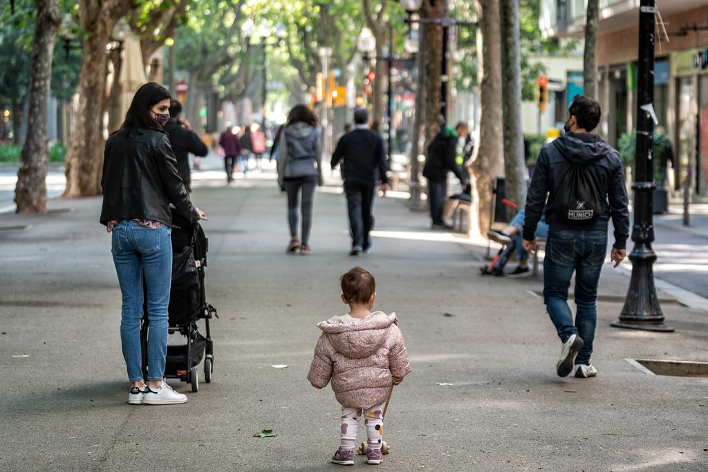 Una família amb un infant camina per la rambla del Poblenou