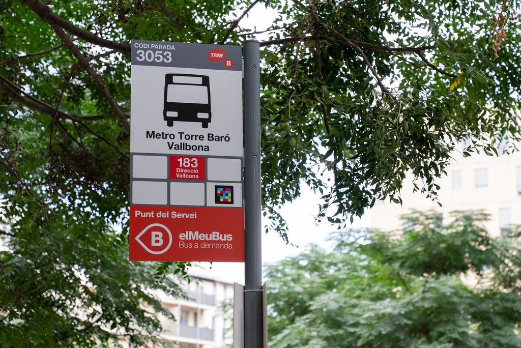 Fotografía de la parada de bus con código 3053 donde para el bus 183. En la parada se informa del nuevo servicio de bus a demanda.