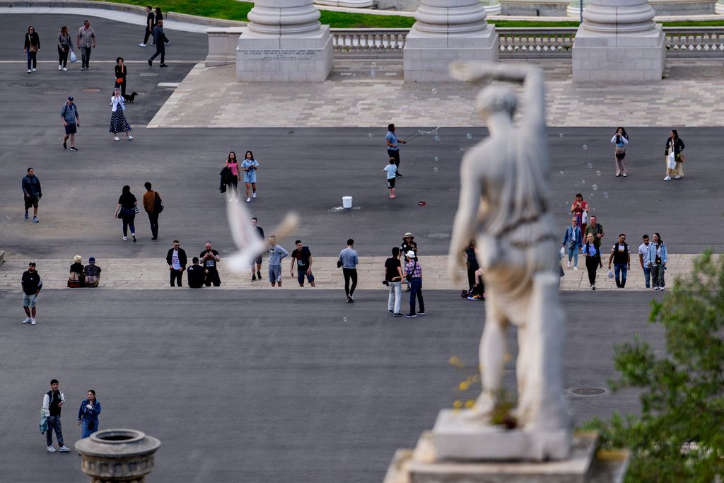 Turistes i visitants al voltant de les Quatre Columnes a la plaça d'Espanya