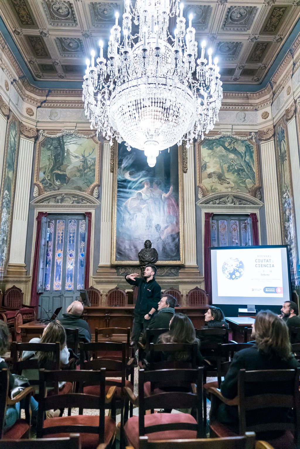 Guia explicant als assistents una de les sales de la Reial Acadèmia de Ciències i Arts de Barcelona