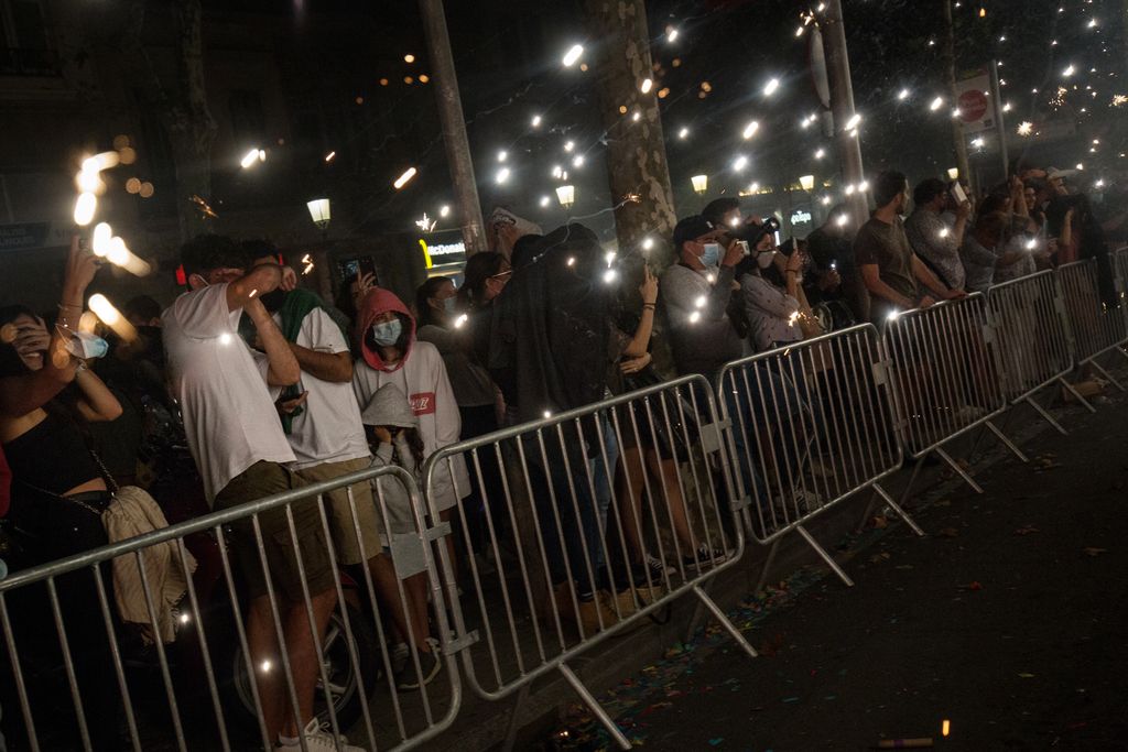 Públic darrere de les tanques de seguretat que segueix les actuacions de les colles de diables durant la Nit del Foc a la Festa Major de la Mercè