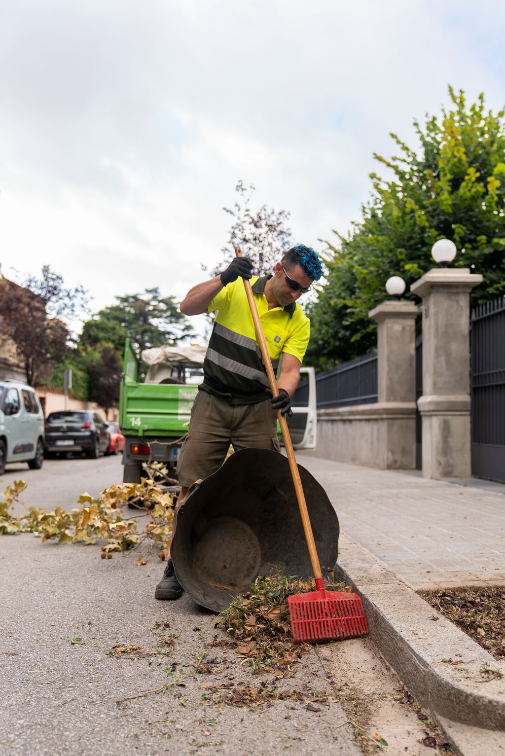 Un treballador de l’equip de Parcs i Jardins escombrant les fulles de la carretera.