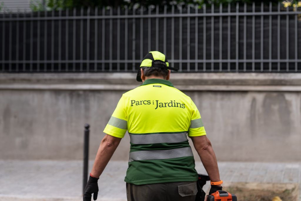 D’esquena, amb uniforme, un treballador de l’equip de Parcs i Jardins.