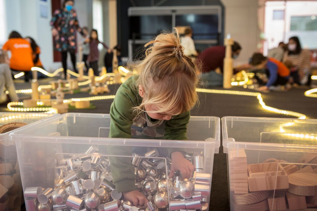 Una nena remena els blocs de construcció metàl·lics d'una caixa al taller "La Città infinita", en el marc de la Barcelona Innova Week 2021