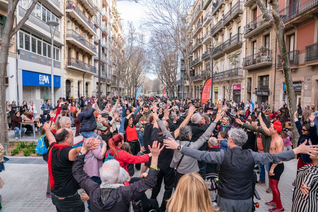 Pla general de l'actuació de l'Acció de Liant la Troca (dansa urbana col·laborativa) durant la festa d'inauguració de la Superilla de Barcelona al carrer de Rocafort, entre Consell de Cent i el carrer de la Diputació.