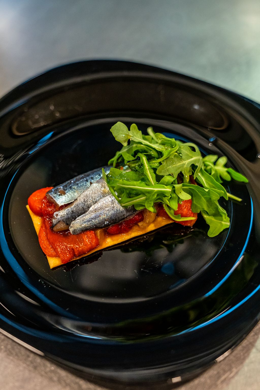 Plat de coca de vidre, verdures escalivades, sardina marinada i amanida de mostassa i ruca del Menú de Primavera elaborat en el marc de Barcelona Capital de l'Alimentació Sostenible 2021