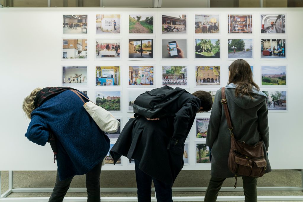 Grup de persones mirant les fotografies de l’exposició “Setze barris. Mil ciutats”. Fotografies per a altres relats de Barcelona