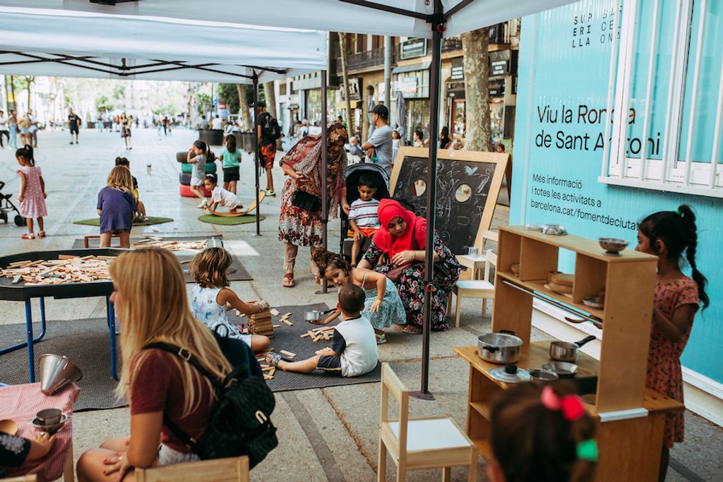Gent participant a les activitats de jocs per a infants a la llosa de l’antic Mercat de Sant Antoni que formen part del Pla de barris