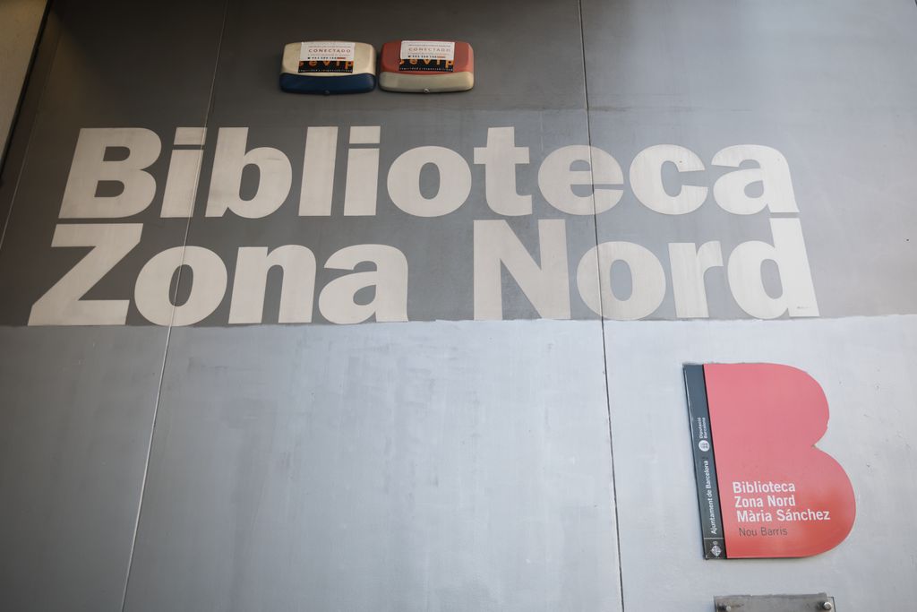 Vista de la entrada de la Biblioteca Zona Nord de Nou Barris, donde se puede ver el logotipo del Ayuntamiento con el nombre de la Biblioteca Zona Nord