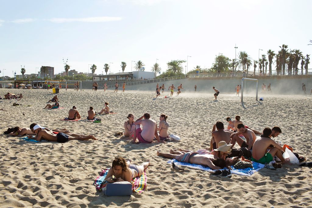 Banyistes i jugadors de futbol platja al darrera