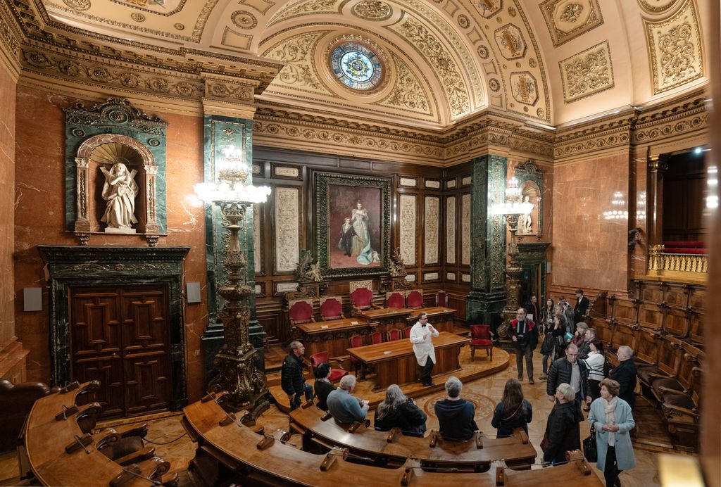 Visitantes escuchan las explicaciones durante la visita teatralizada al Saló de Plens Carles Pi i Sunyer con motivo de Santa Eulàlia