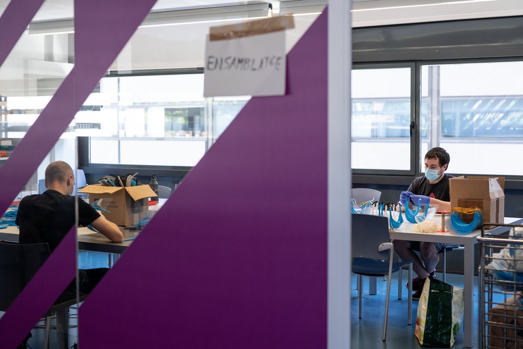 Dues persones munten viseres amb peces obtingudes al Parc Tecnològic de Barcelona Activa a la sala d'"Ensamblatge"