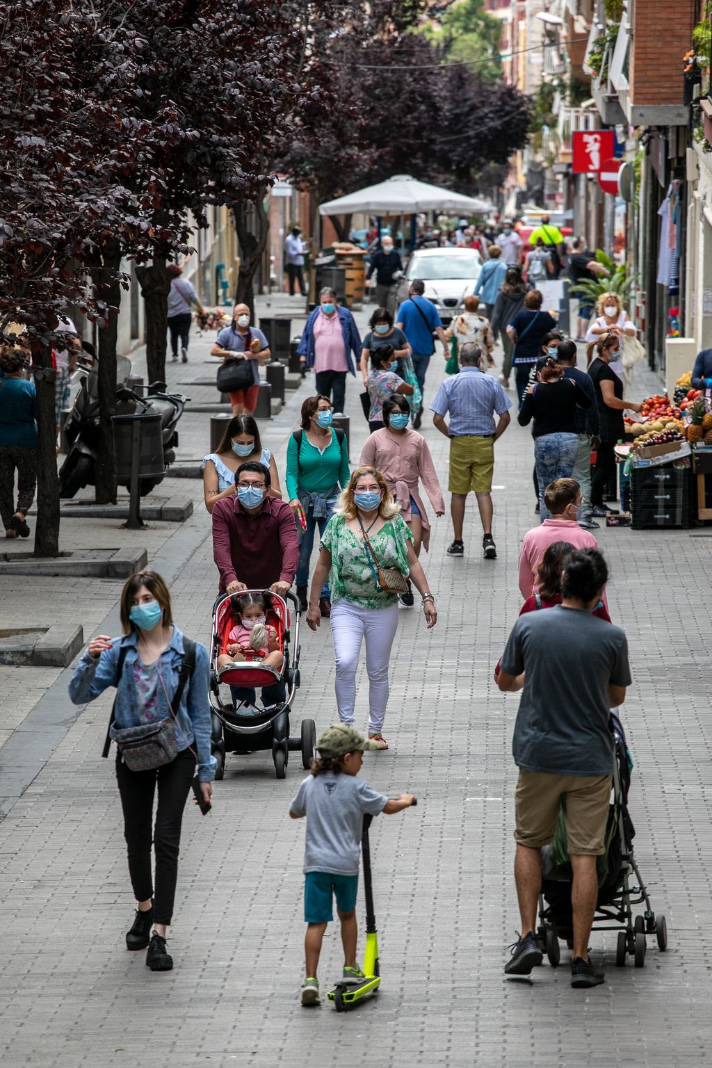 Vista general del carrer de Joaquim Valls amb gent de totes les edats anant i venint amb les mascaretes posades