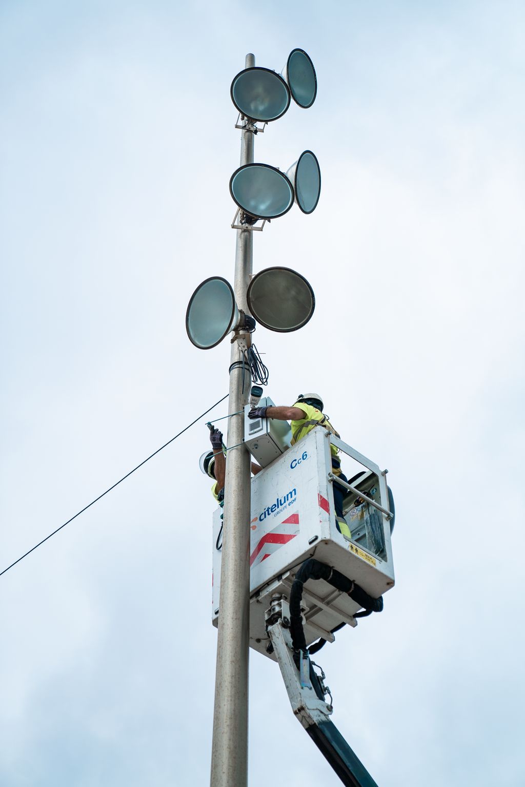 Uns operaris dalt de la grua instal·len els sensors de control de capacitat