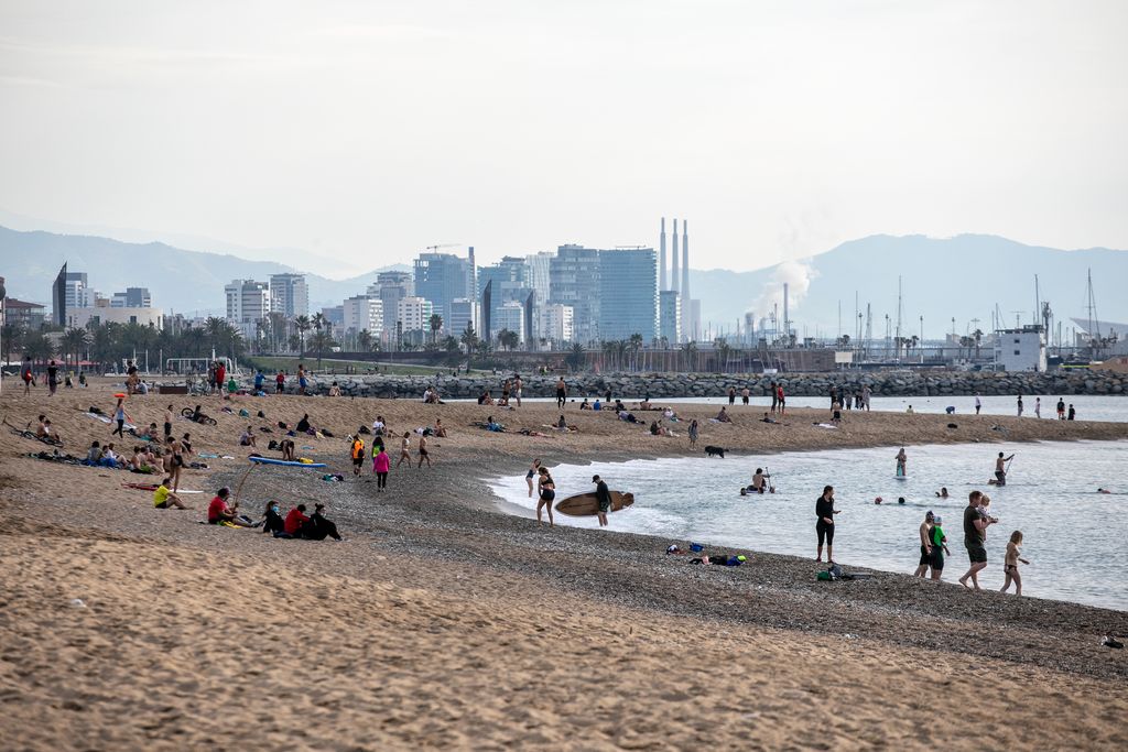 Grups d'amics i famílies gaudint de la platja