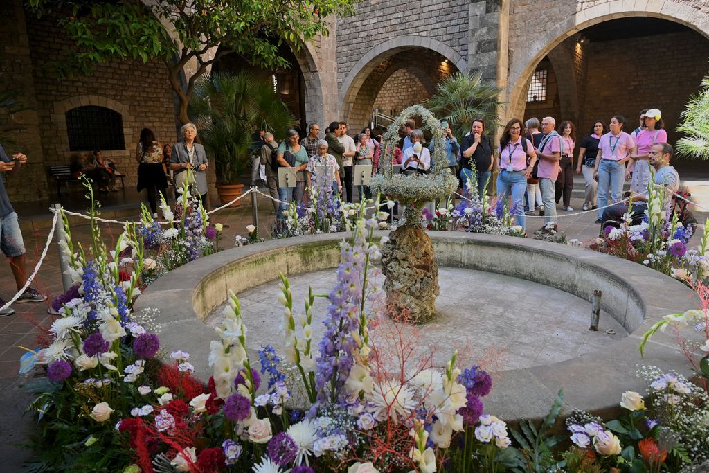 Gent mirant la font guarnida per l'Ou com balla amb motiu de Corpus al pati del Museu Frederic Marès. Per la sequera, no raja aigua i l'ou està agafat per un fil.