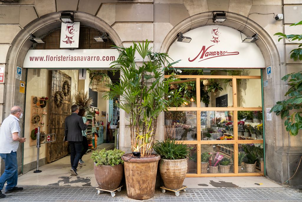 Gent que entra a comprar en una floristeria