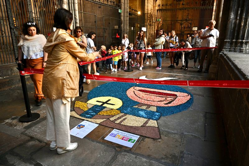 
             Gent visitant una catifa floral amb motius eucarístics al claustre de la Cate...
             Autor: Pep Herrero
             Mostra els detalls de la imatge Gent visitant una catifa floral amb motius eucarístics al claustre de la Cate...
             