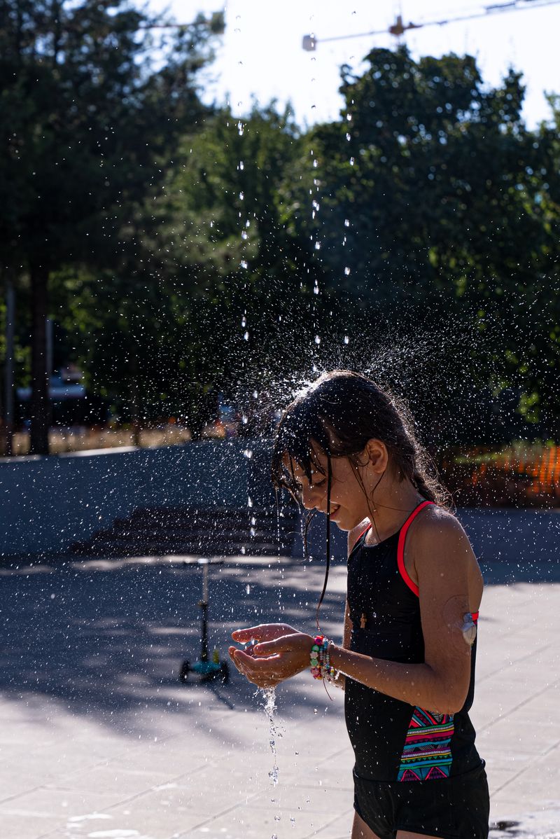 
             Una nena en banyador es refresca a la zona d
