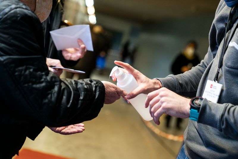 
             Un treballador del dispositiu electoral posa gel hidroalcohòlic a les mans d