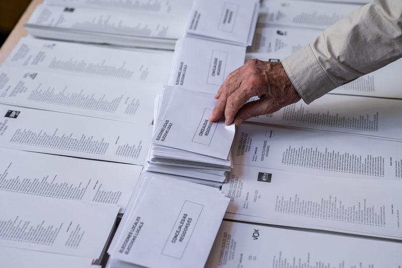 
             Detall d’una mà agafant un sobre durant la jornada d’eleccions municipals 2023.
             Autor: Àlex Losada
             Mostra els detalls de la imatge Detall d’una mà agafant un sobre durant la jornada d’eleccions municipals 2023.
             