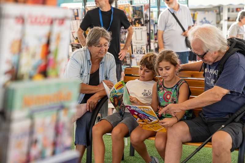 
             Un nen petit i una nena petita, acompanyats dels seus avis, fullegen dues rev...
             Autor: Lucas Amillano
             Mostra els detalls de la imatge Un nen petit i una nena petita, acompanyats dels seus avis, fullegen dues rev...
             